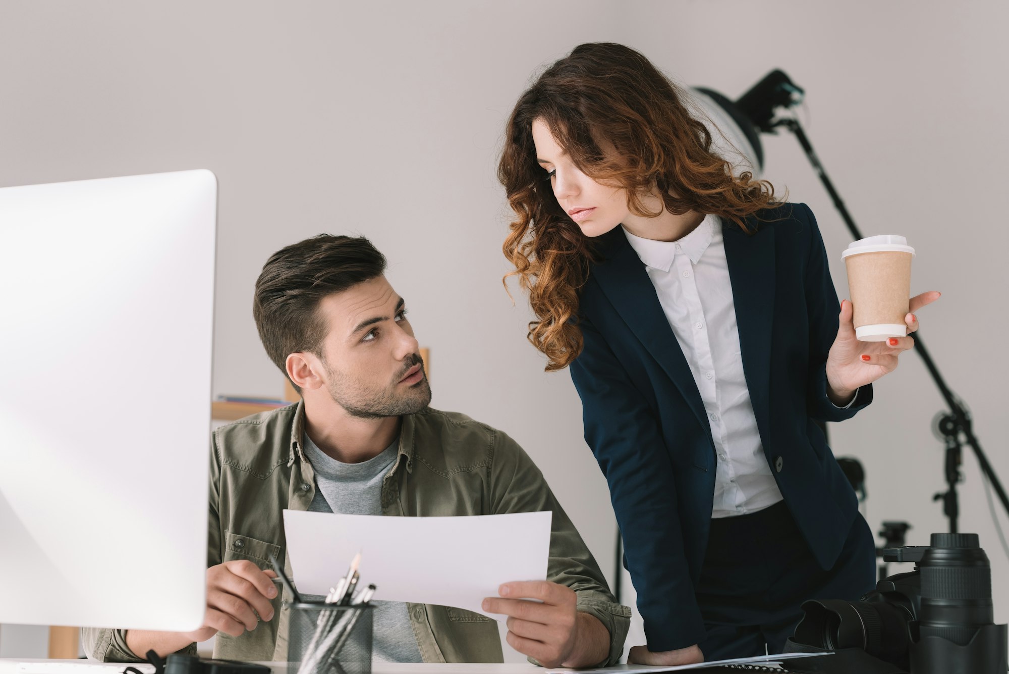 male photographer and model choosing photos for portfolio in modern office