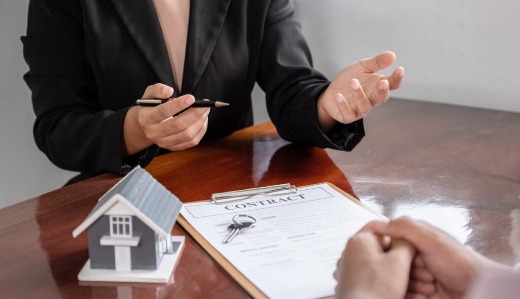 hand. The real estate agent explains the business contract