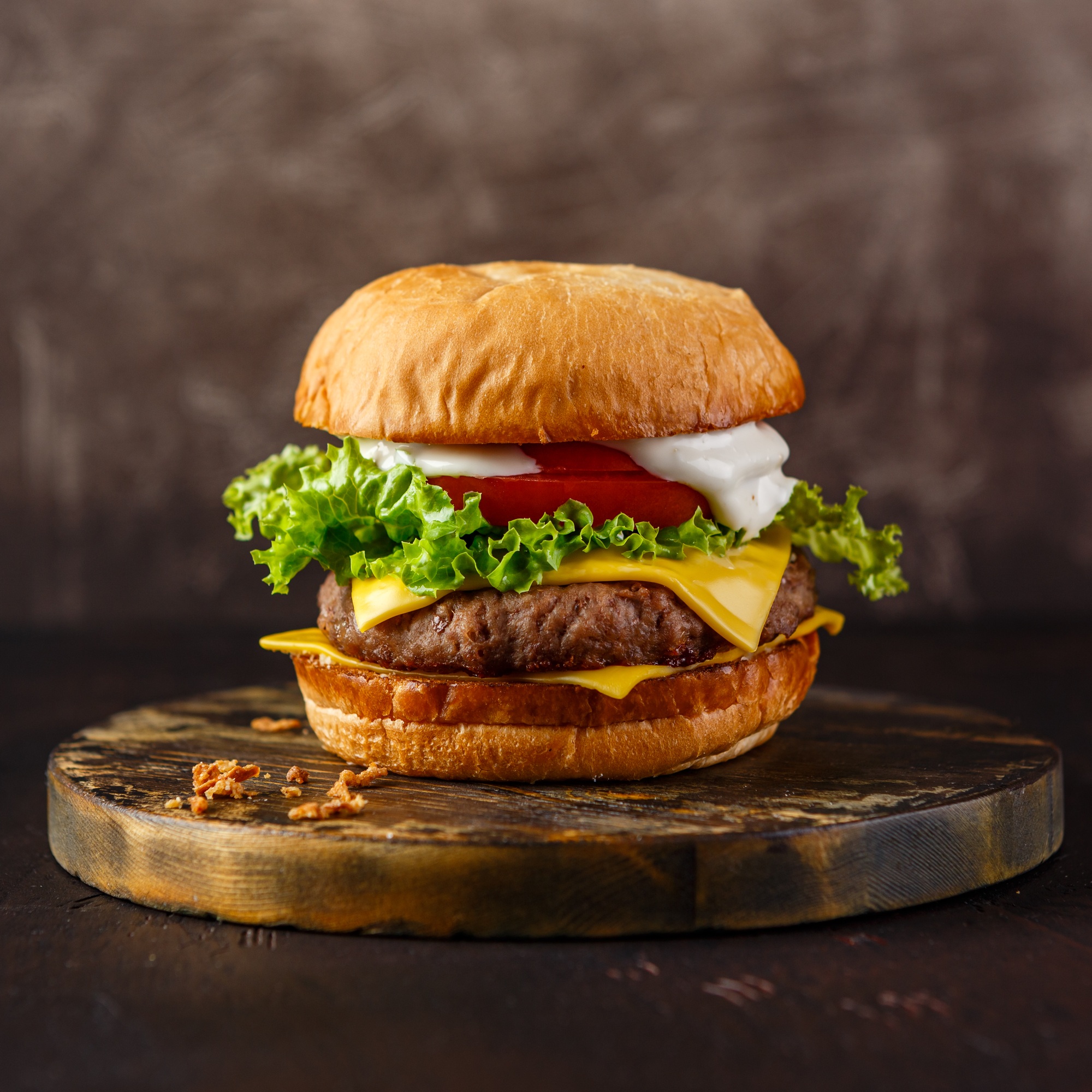 Close-up of home made tasty burger on wooden table.
