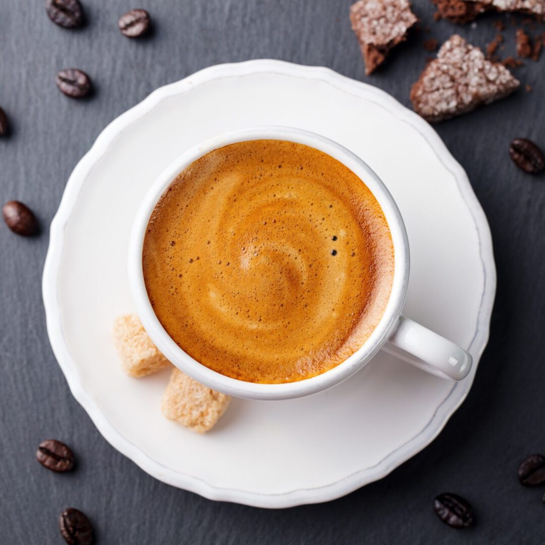 Coffee Espresso in White Cup on Black Slate Background. Top View.