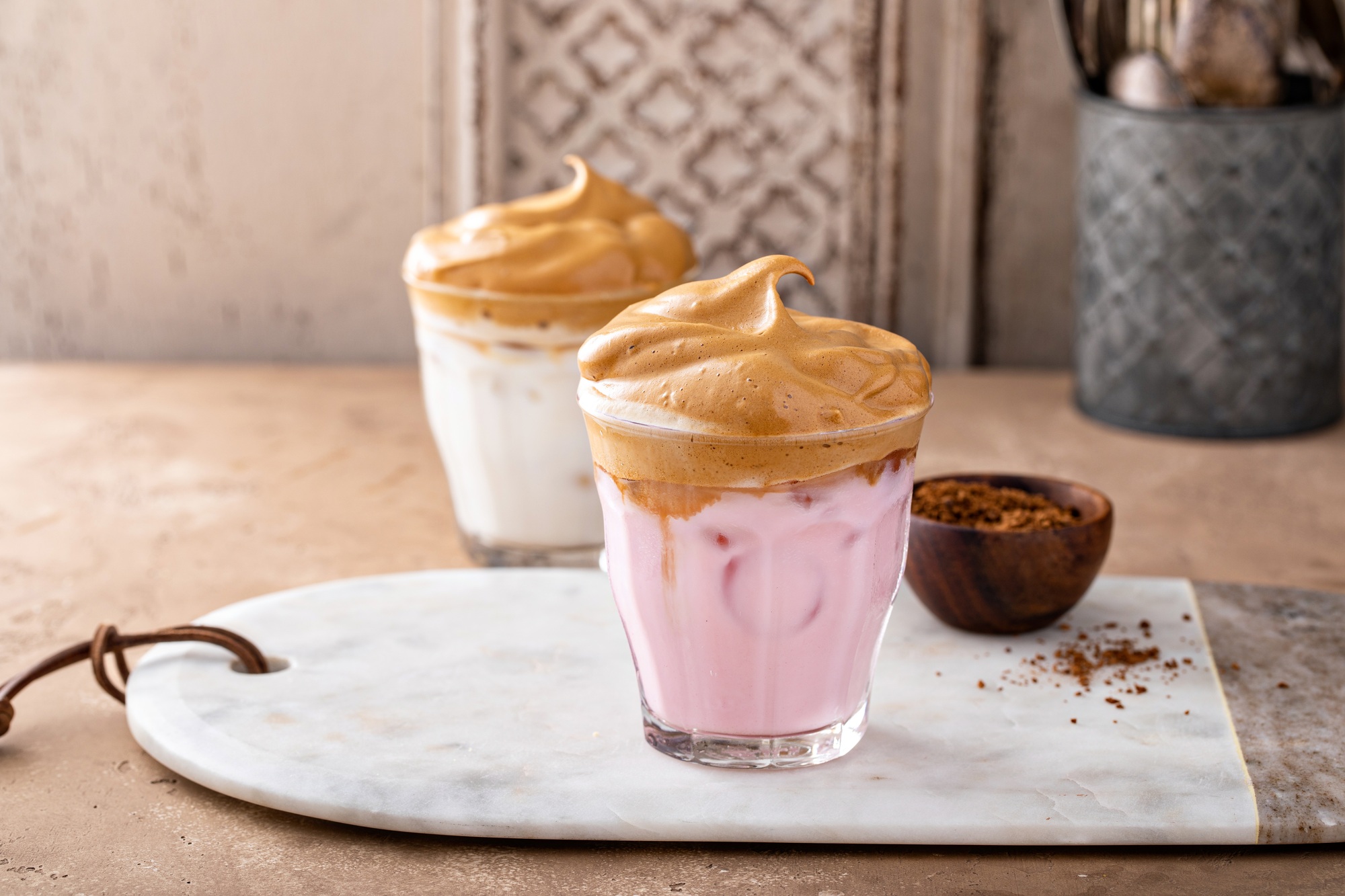 Dalgona whipped coffee with iced strawberry milk in a glass, trendy coffee drink