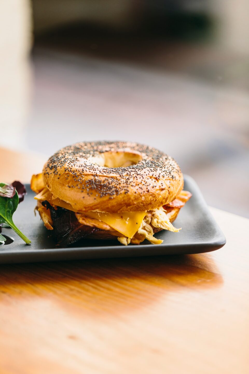 Tasty bagel sandwich on table in cafe