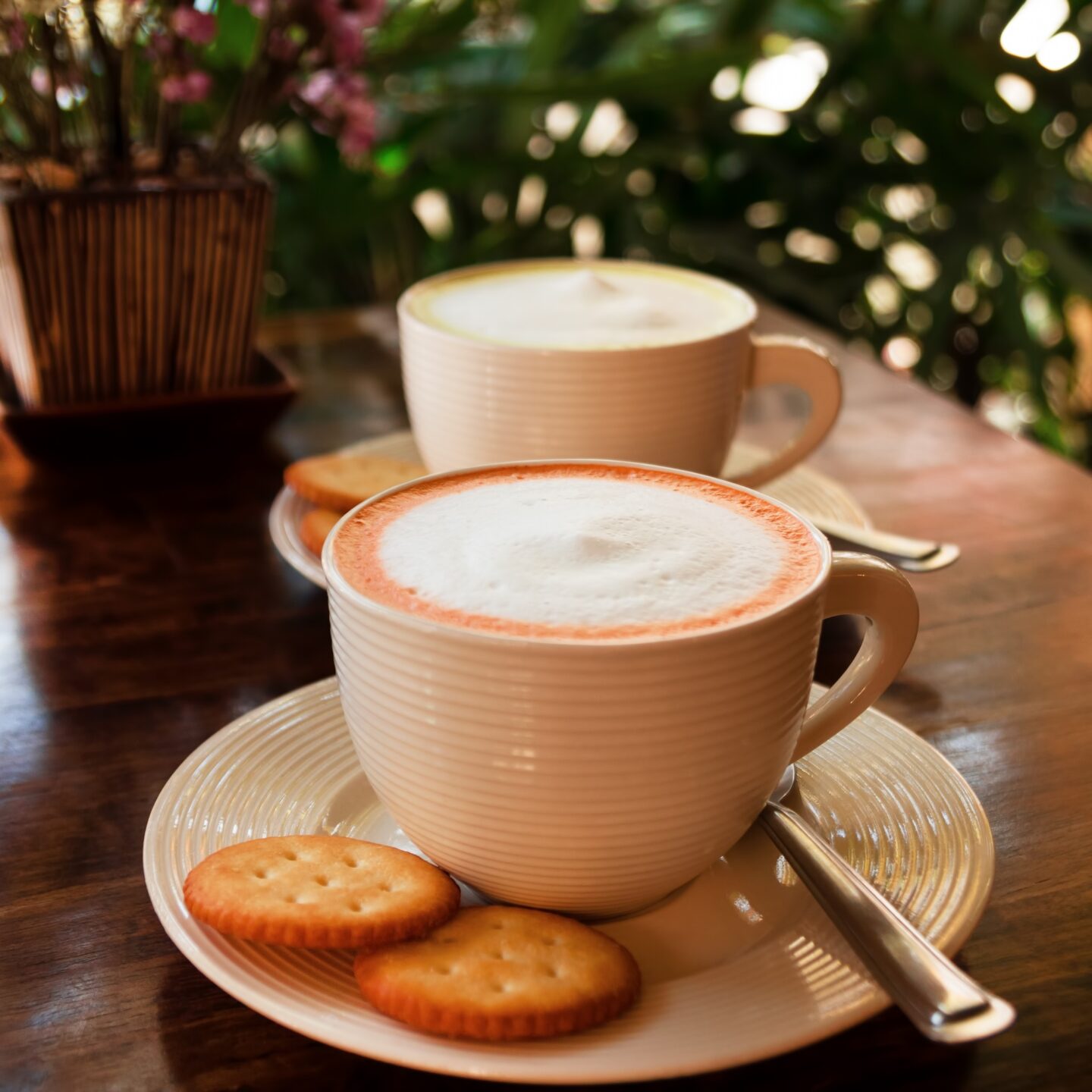 The couple cups with colorful Thai milk tea on a wooden table in a cafe.