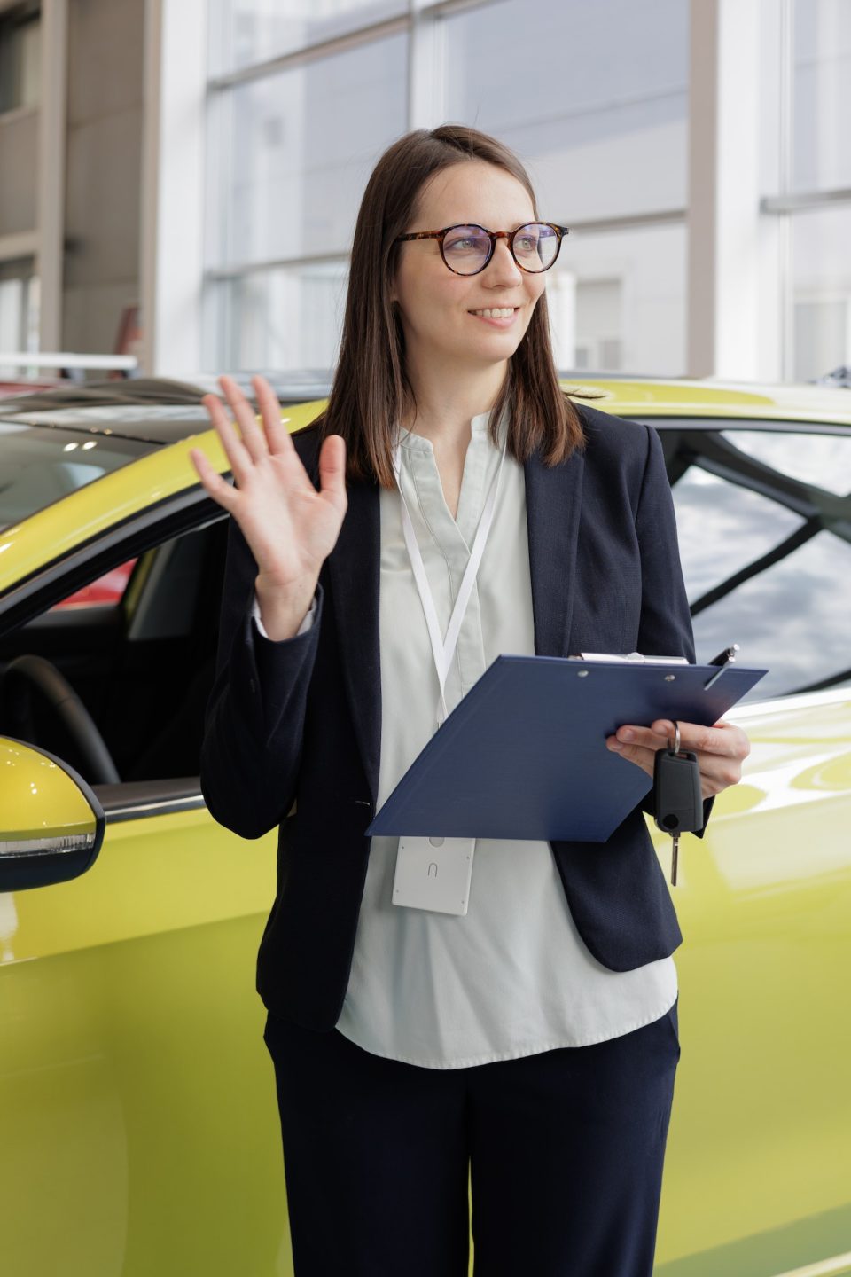 woman sells a car at a car dealership and hands over the keys to the buyer. nice woman car sales