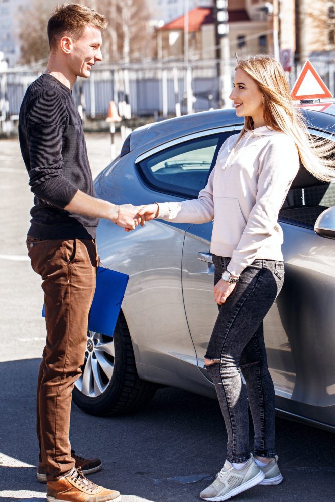 Acquaintance of a driving instructor and a student near a training car