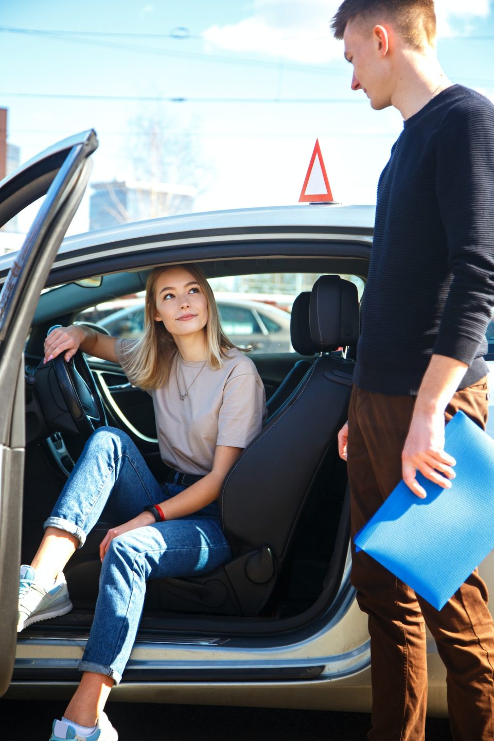 Driving instructor and woman student in examination car.