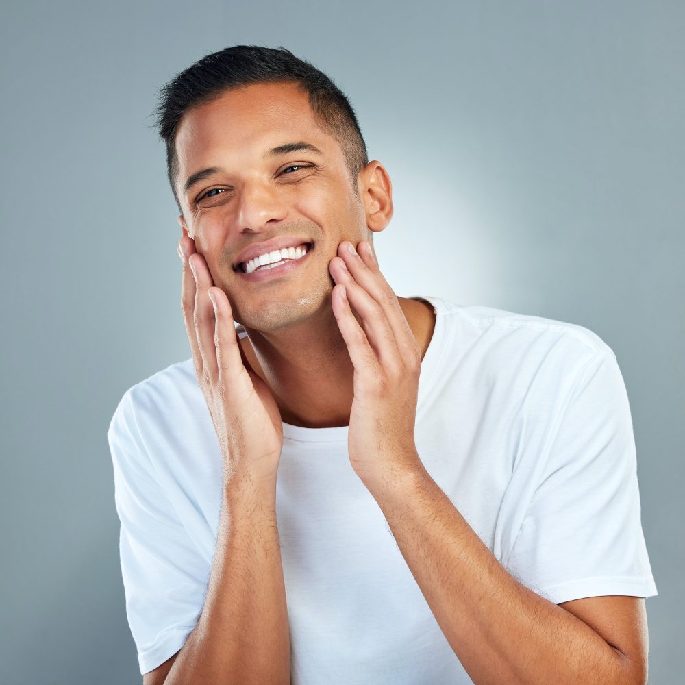 Man, smile and face with skincare, beauty and dermatology in studio for cleaning, hygiene and healt