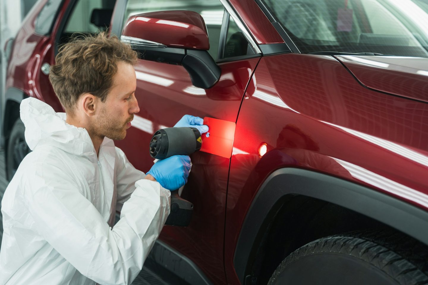 Professional auto painter matches car paint color with lamp and samples