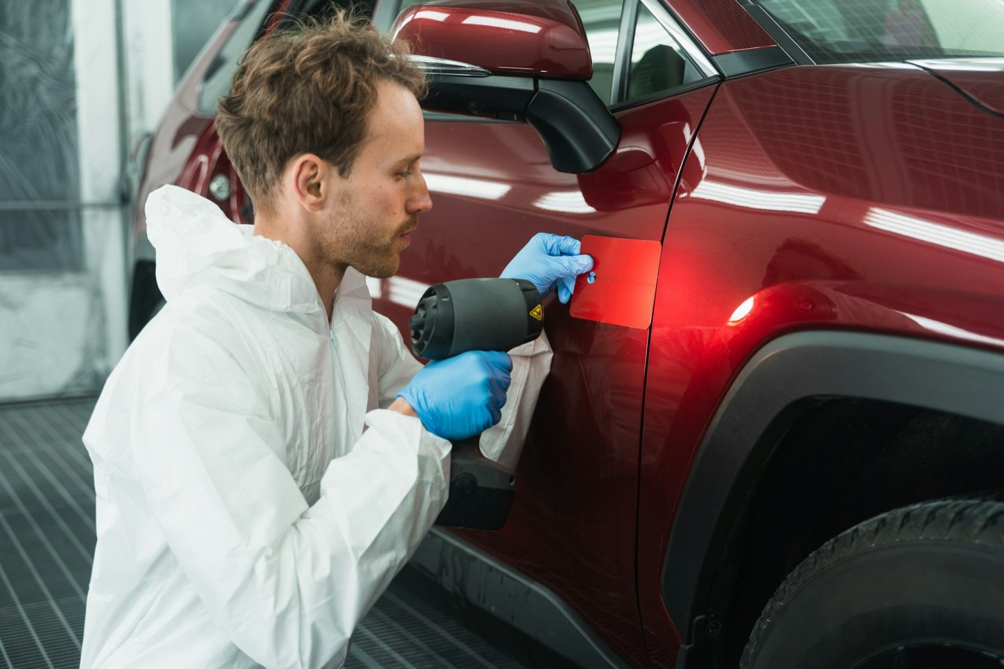 Professional auto painter matches car paint color with lamp and samples