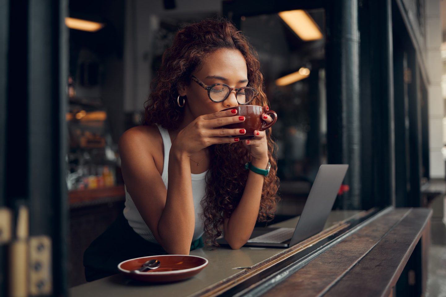 Coffee shop, laptop and black woman with remote work for copywriting, website marketing or working