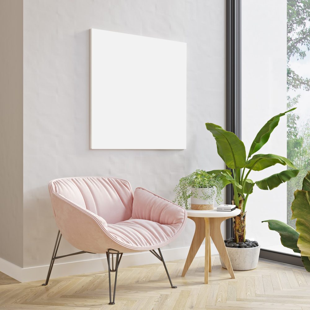 Picture mockup on light wall above modern pink armchair and plants. Modern minimalistic