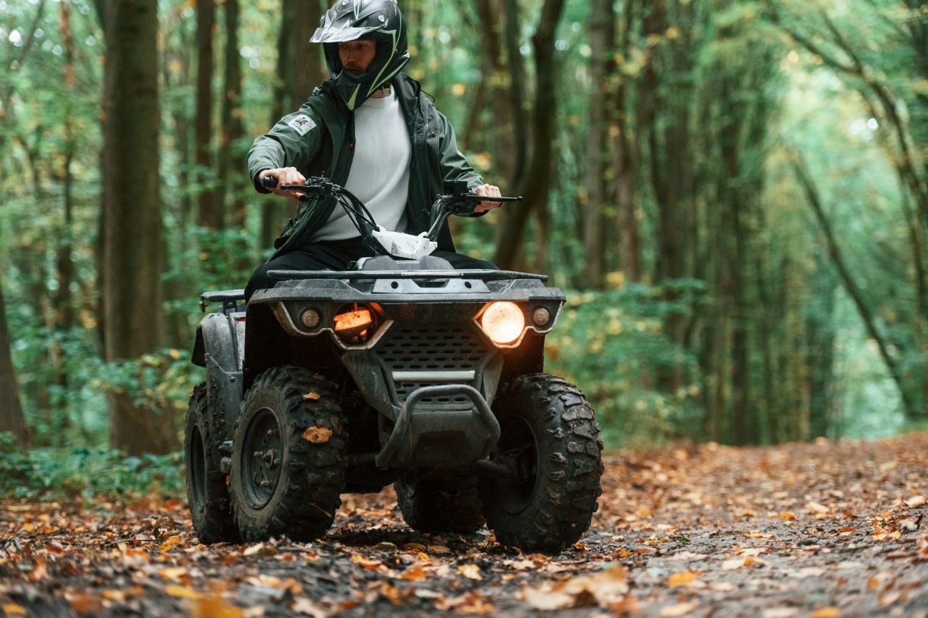 ATV driver is in the forest, having a ride at daytime