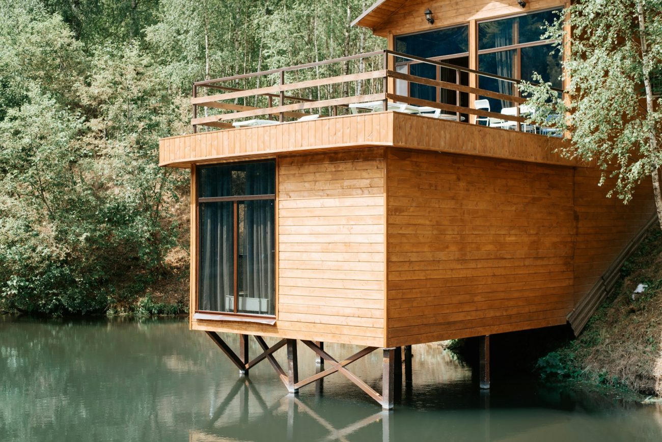 Modern wooden loft house on the lake, close-up. Exterior of a country house with a balcony, cottage
