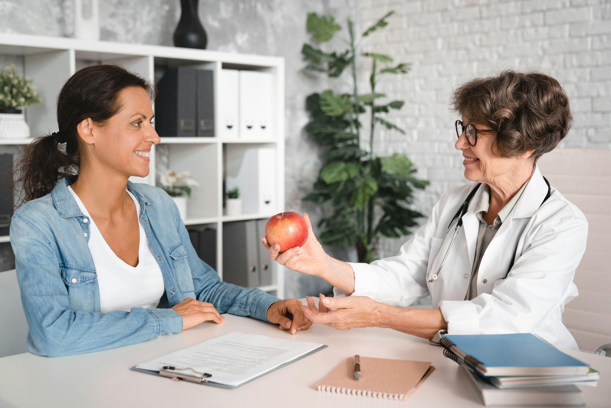 Dietologist talking about nutrition, dietary additives, supplements, diet weight loss holding apple