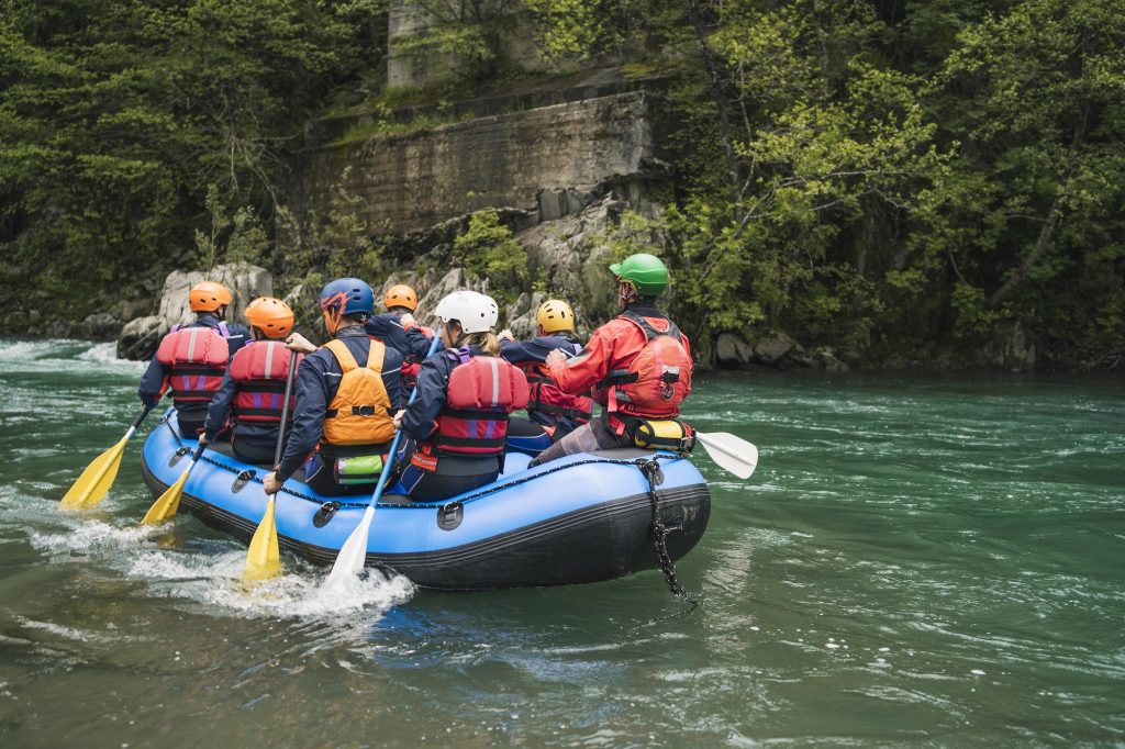 Group of people rafting in rubber dinghy on a river