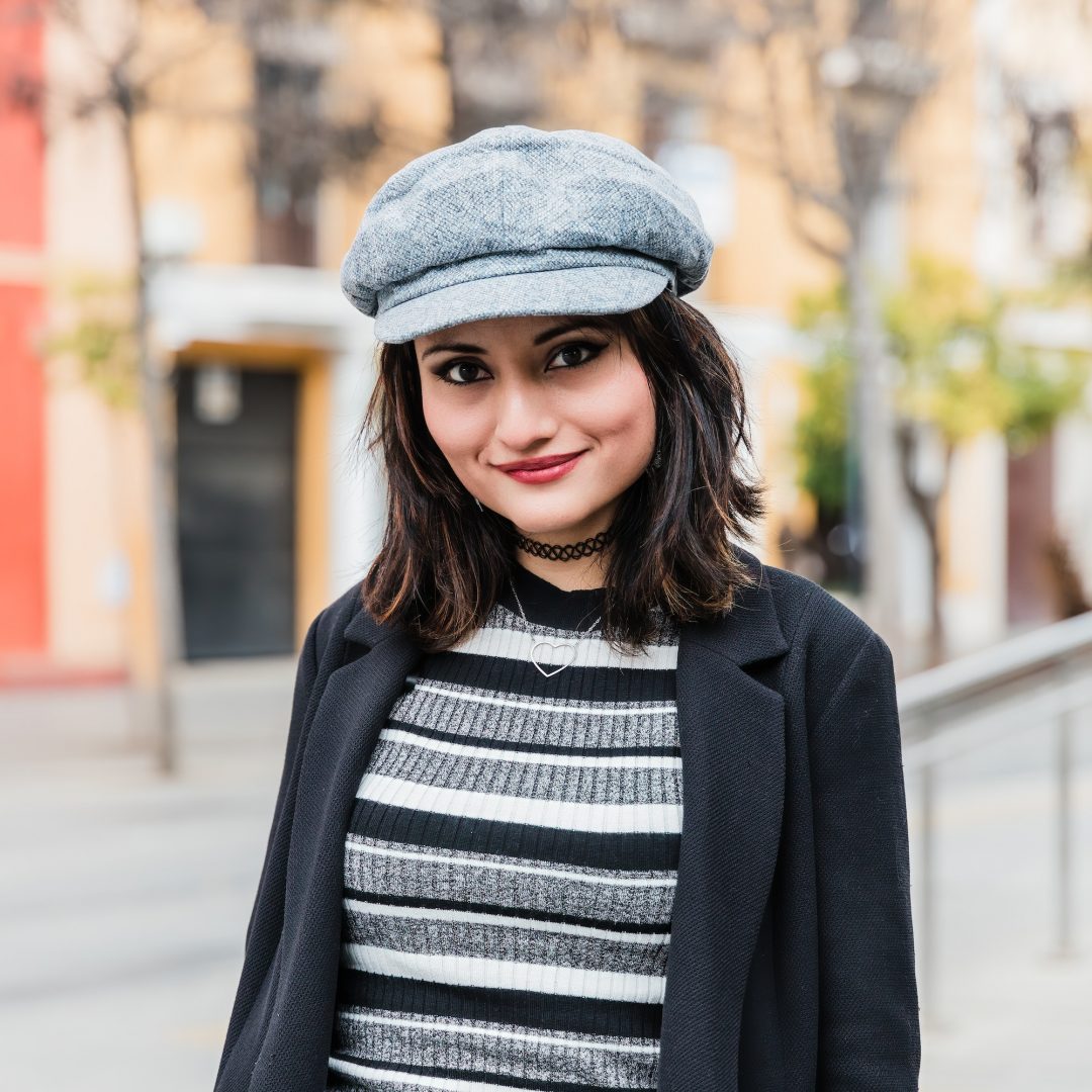 Smiling ethnic lady looking at camera on street in autumn