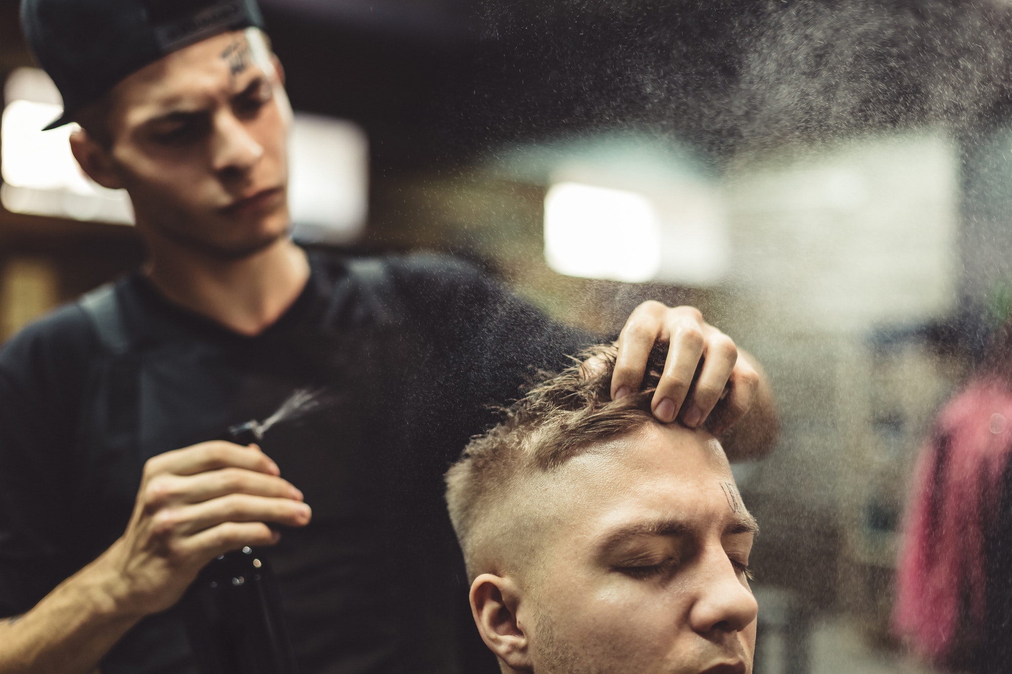 Stylist grooming client in barbershop
