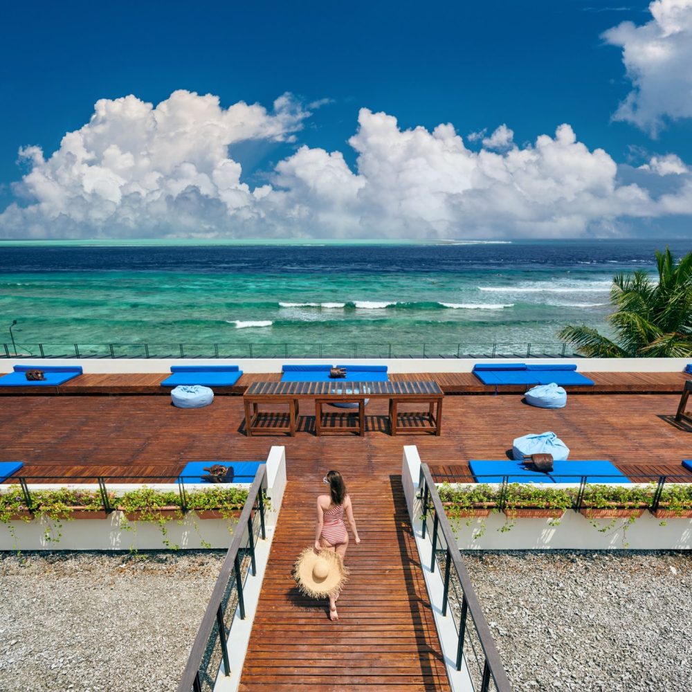 Woman in striped swimsuit on beach patio
