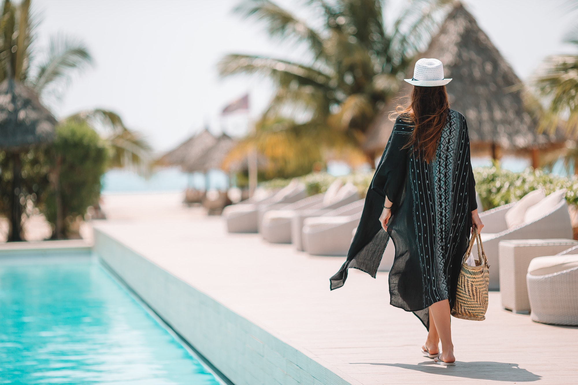 Woman relaxing by the pool in a luxury hotel resort enjoying perfect beach holiday vacation
