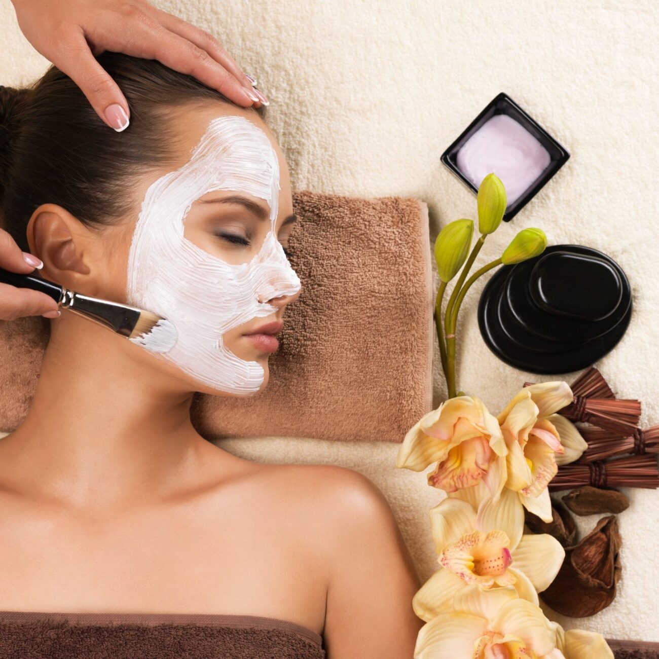 Woman having a facial cosmetic mask at spa salon.