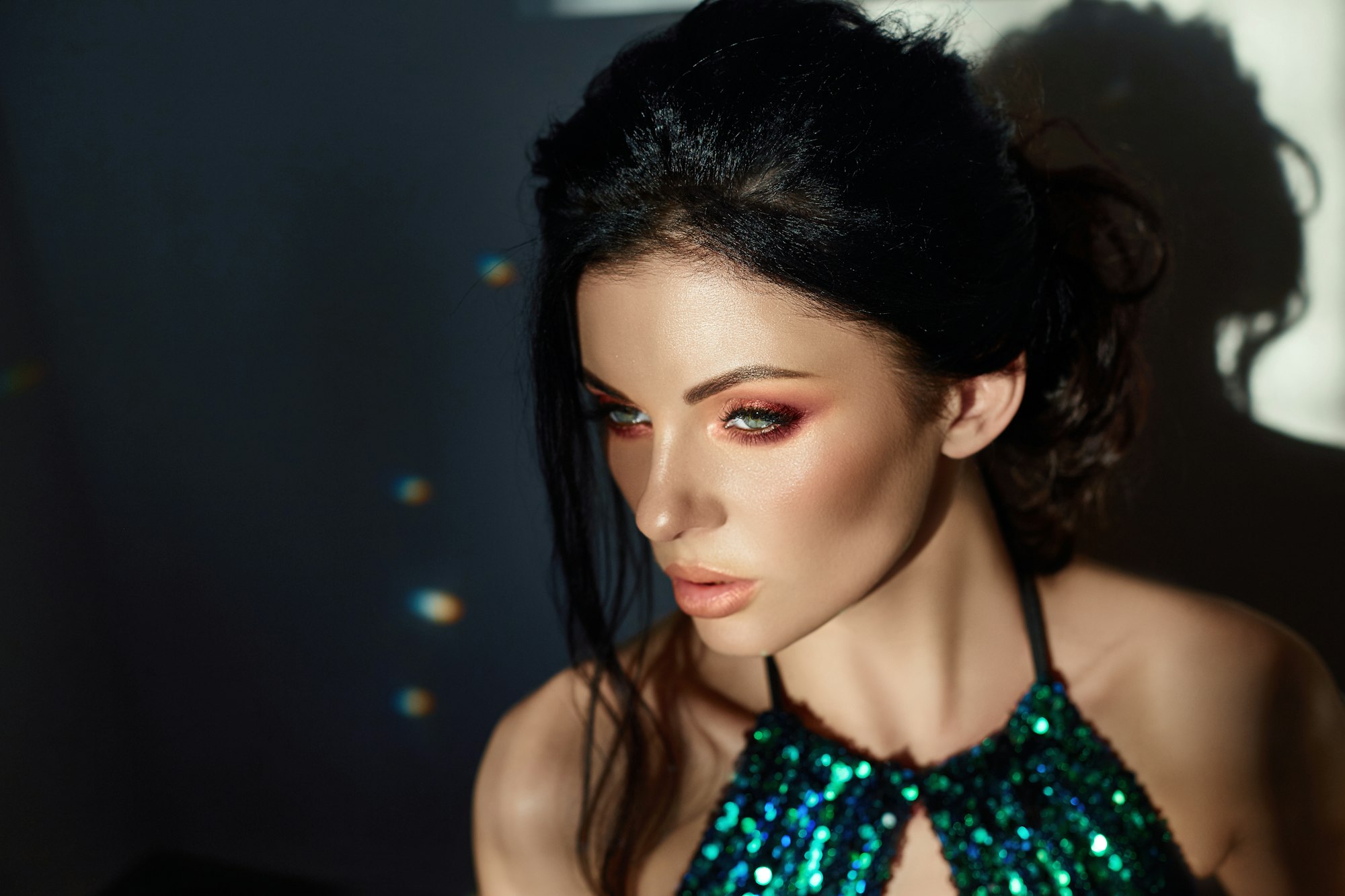 Art Fashion portrait of a woman in a shiny swimsuit, beautiful makeup, sunset rays on her face