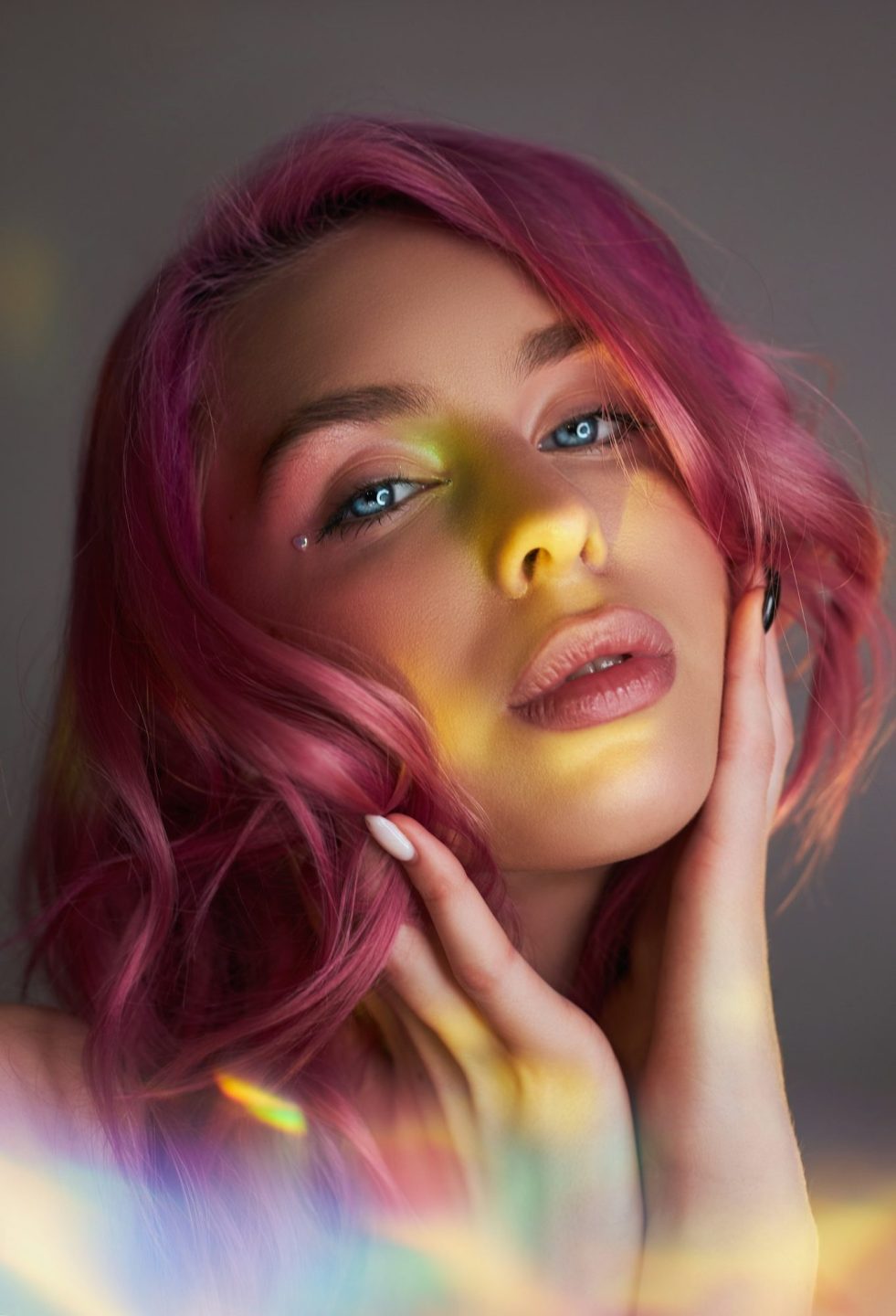 Beauty portrait woman with pink hair, creative vivid coloring. Bright colored highlights and shadows