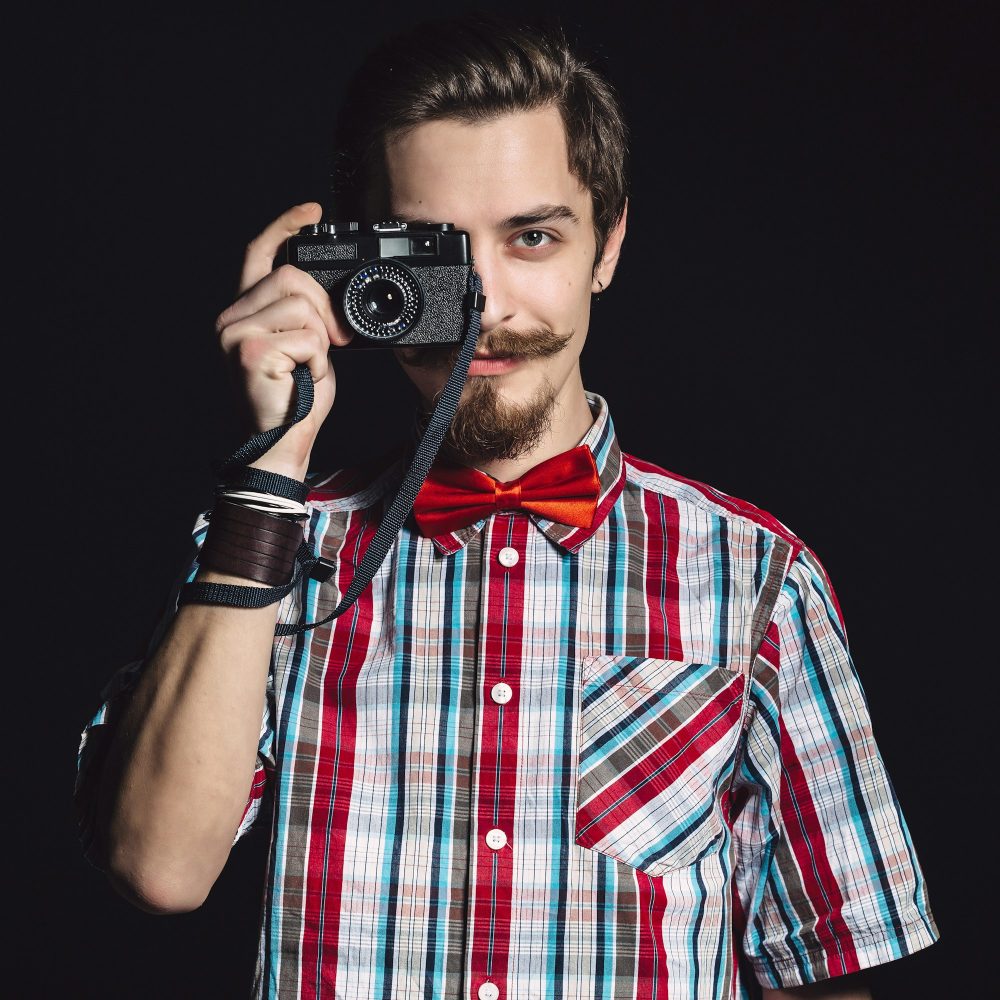 Portrait of a cheerful photographer in studio