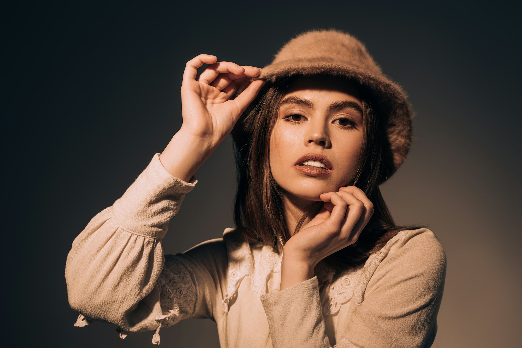 portrait of fashionable woman in hat looking at camera