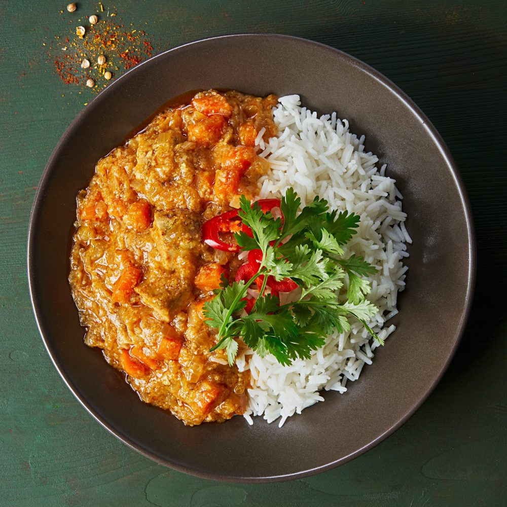 Chicken tikka masala spicy curry meat food in plate with rice.