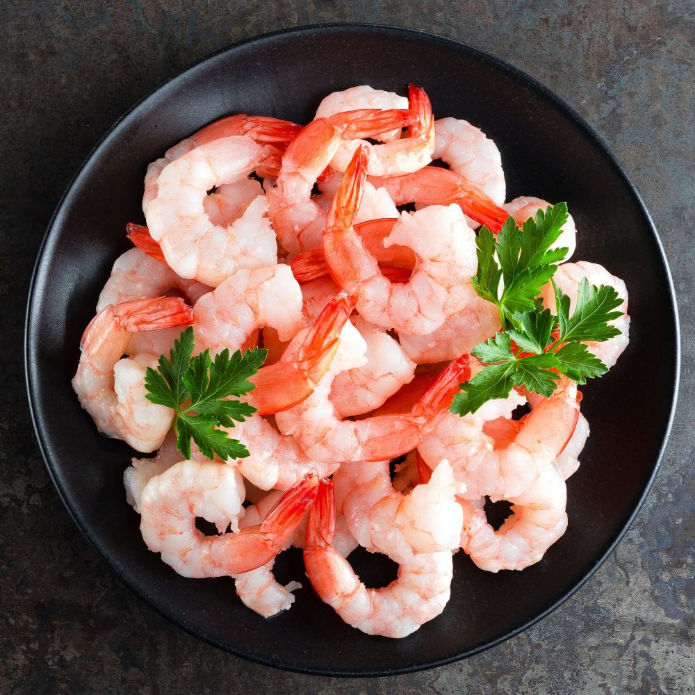 Prawns on plate. Shrimps, prawns. Seafood. Top view. Dark background