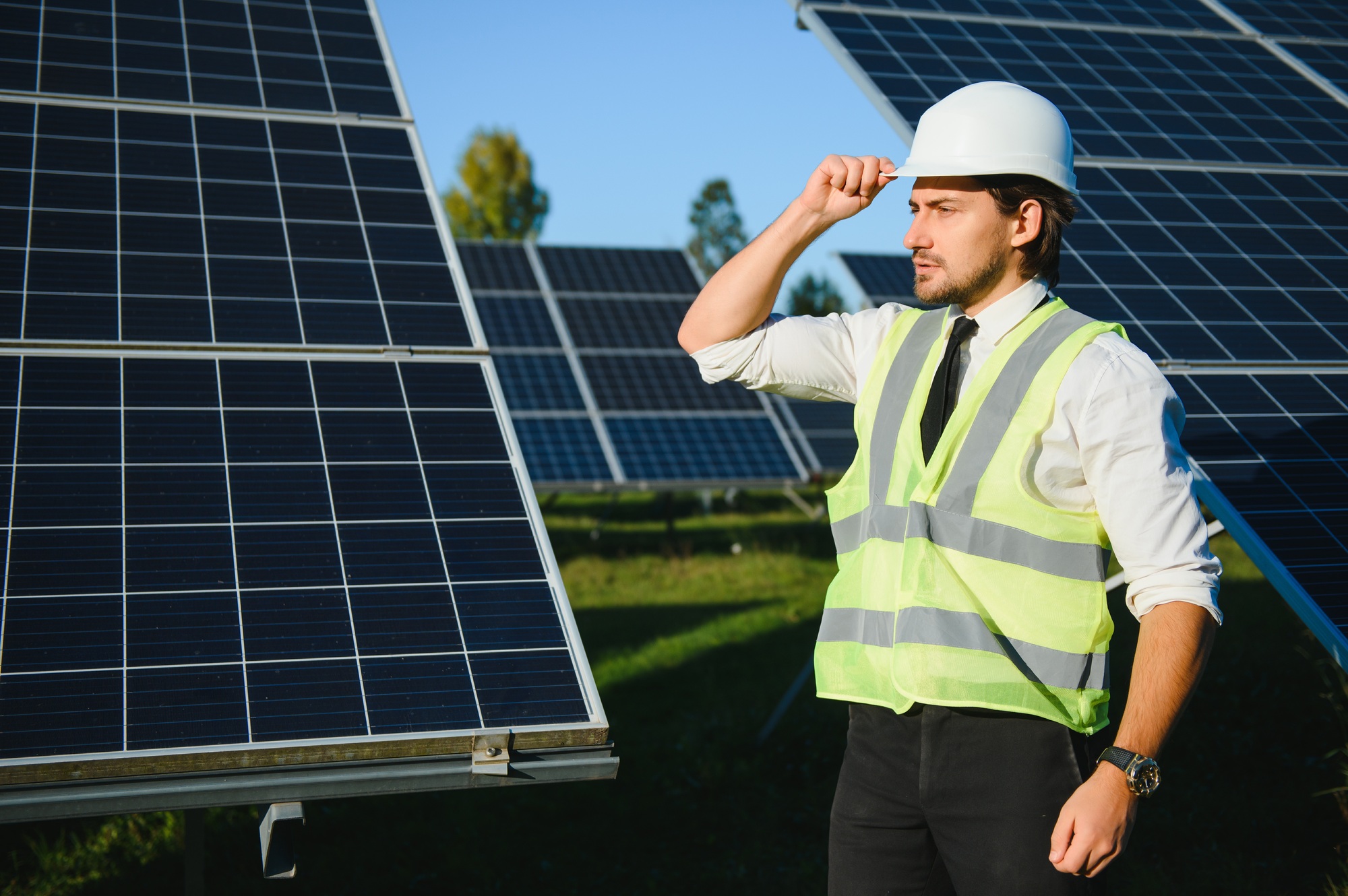 Solar power plant. Man standing near solar panels. Renewable energy