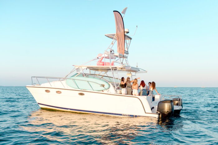 Youth party on vacation at sea. Girlfriends drink champagne, dance on the yacht
